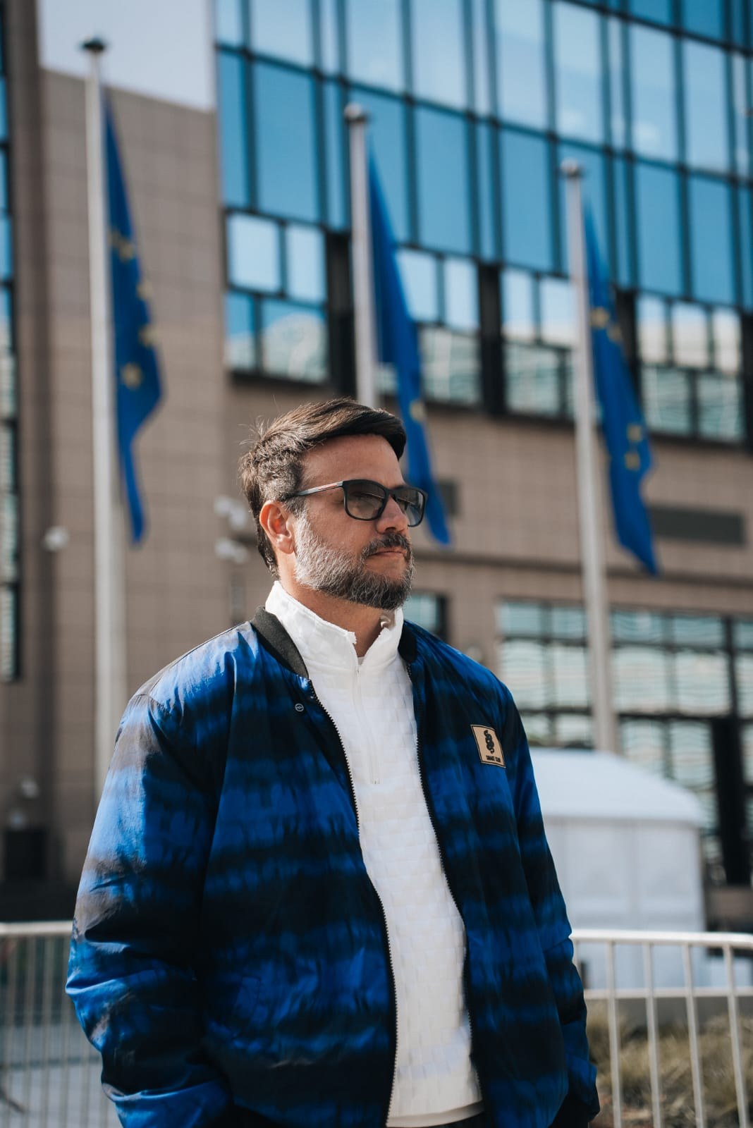 Pr. Jediael Rosa diante de prédio com bandeiras da União Europeia, em Bruxelas