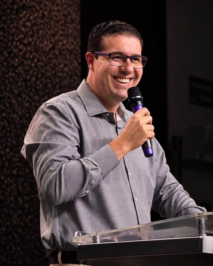 Pr. Geraldo Majella sorrindo ao microfone no púlpito
